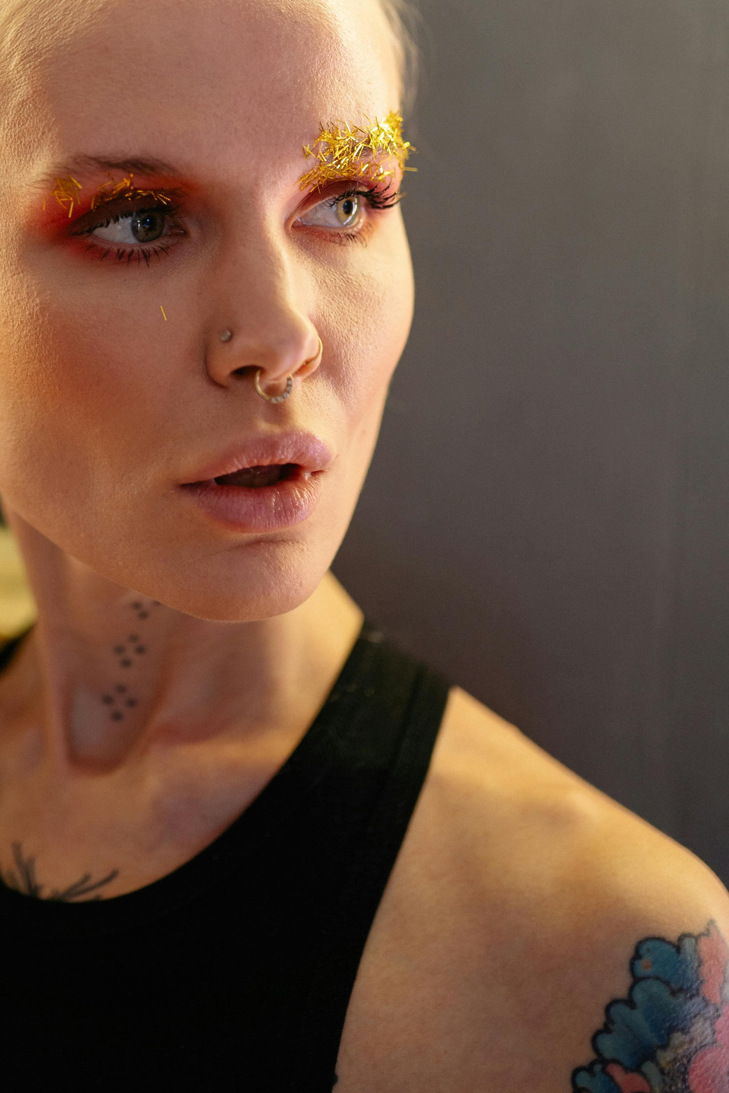 Close-up portrait with facial piercings and tattoos